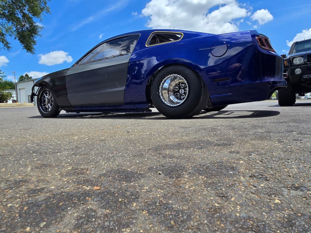 Blue and black drag-prepped Mustang on drag wheels.