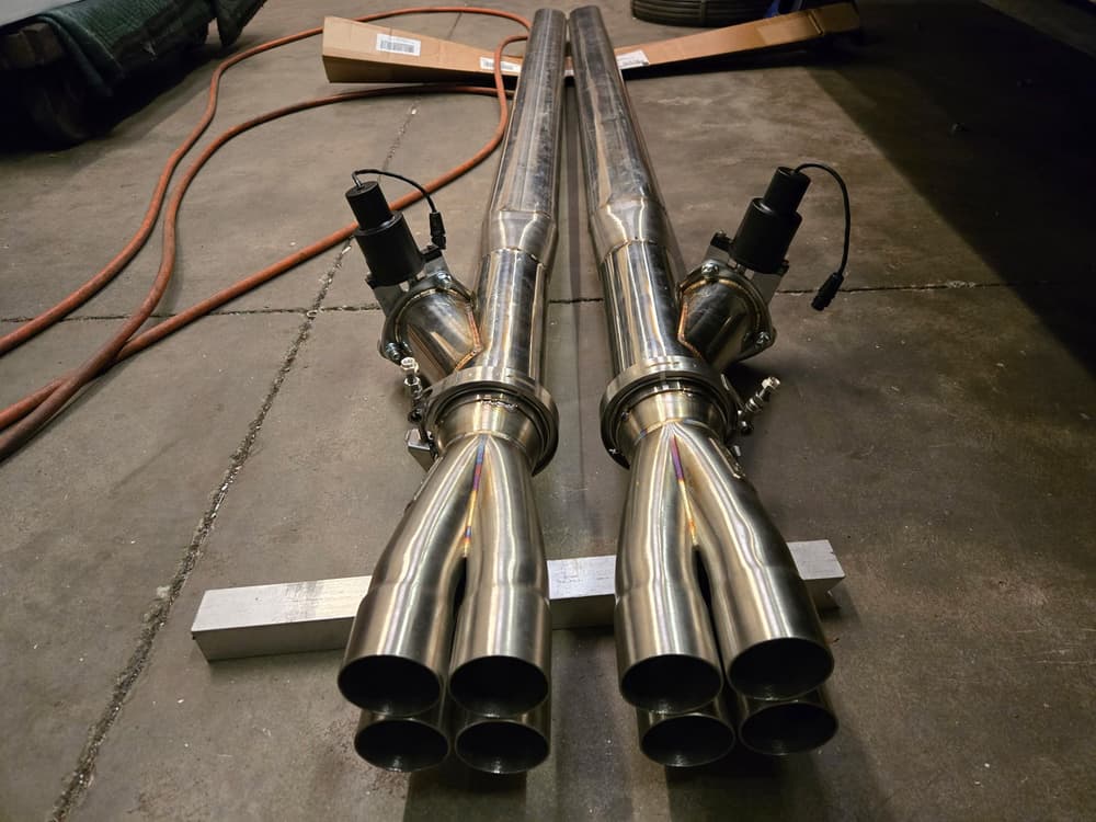 Two fabricated stainless steel exhaust merge collectors with electronic cutouts.